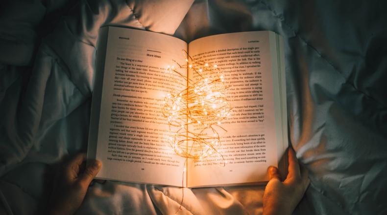 hands holding a book with lights in it