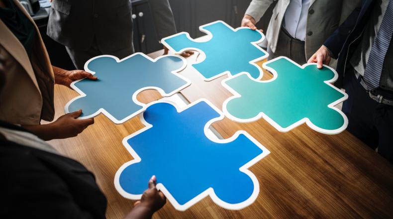 People putting a large jigsaw puzzle together