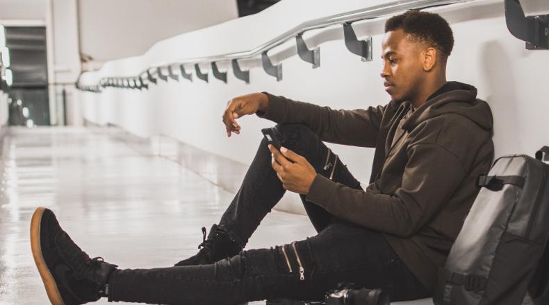 man sitting on floor at airport