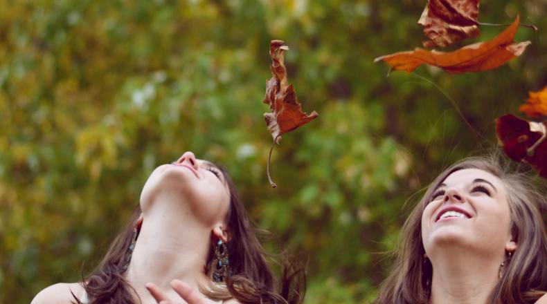 women throwing leaves