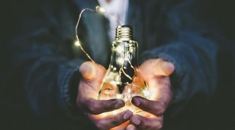 someone holding  a lightbulb in their hands