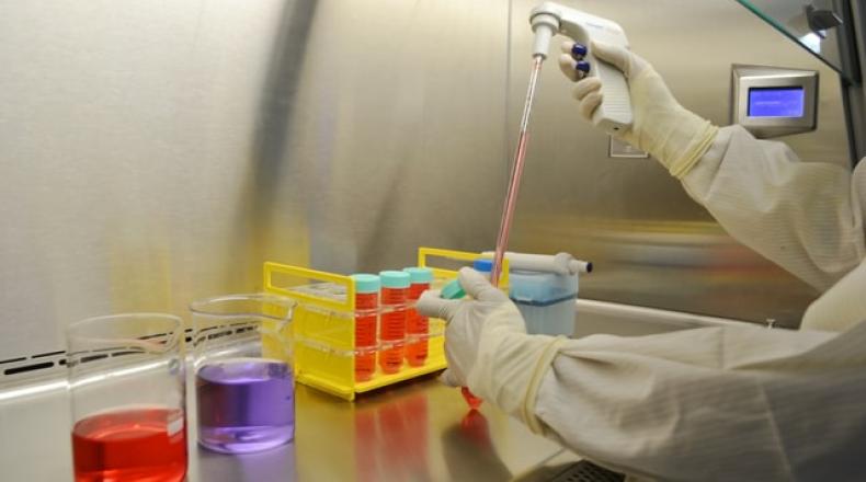 lab technician with beakers with different colored liquids