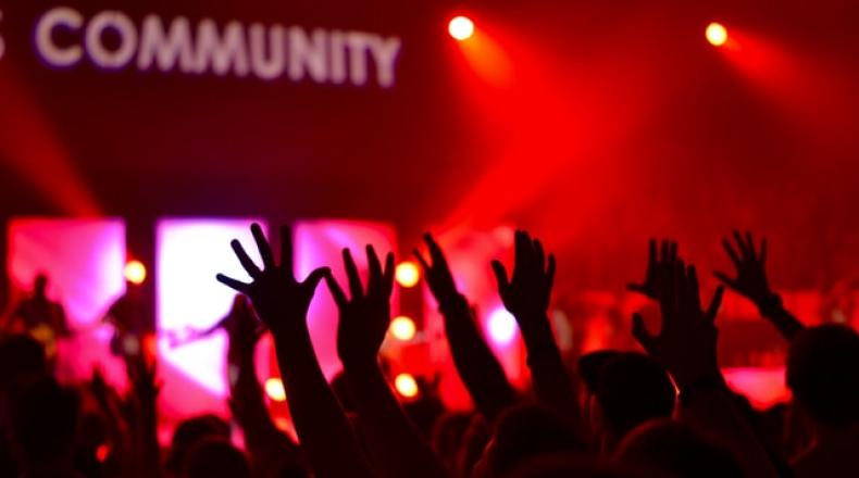 hands reaching towards sign that says community