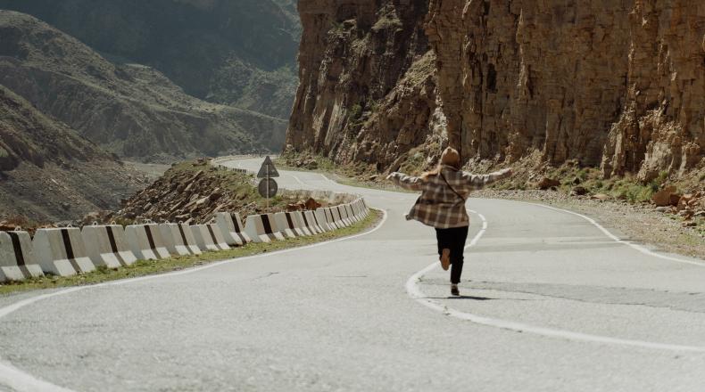 Running on road with arms open