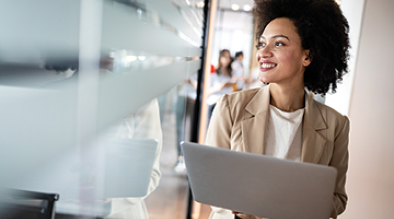 woman with a laptopn looking out a window