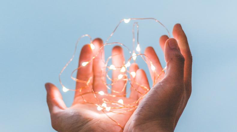 hands holding strand of white lights