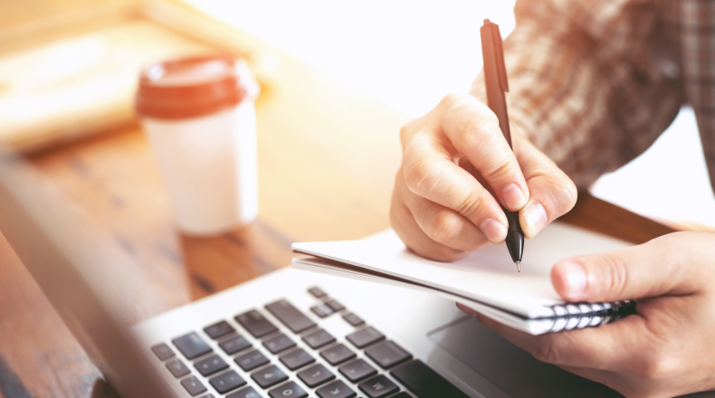 Person taking notes at a laptop