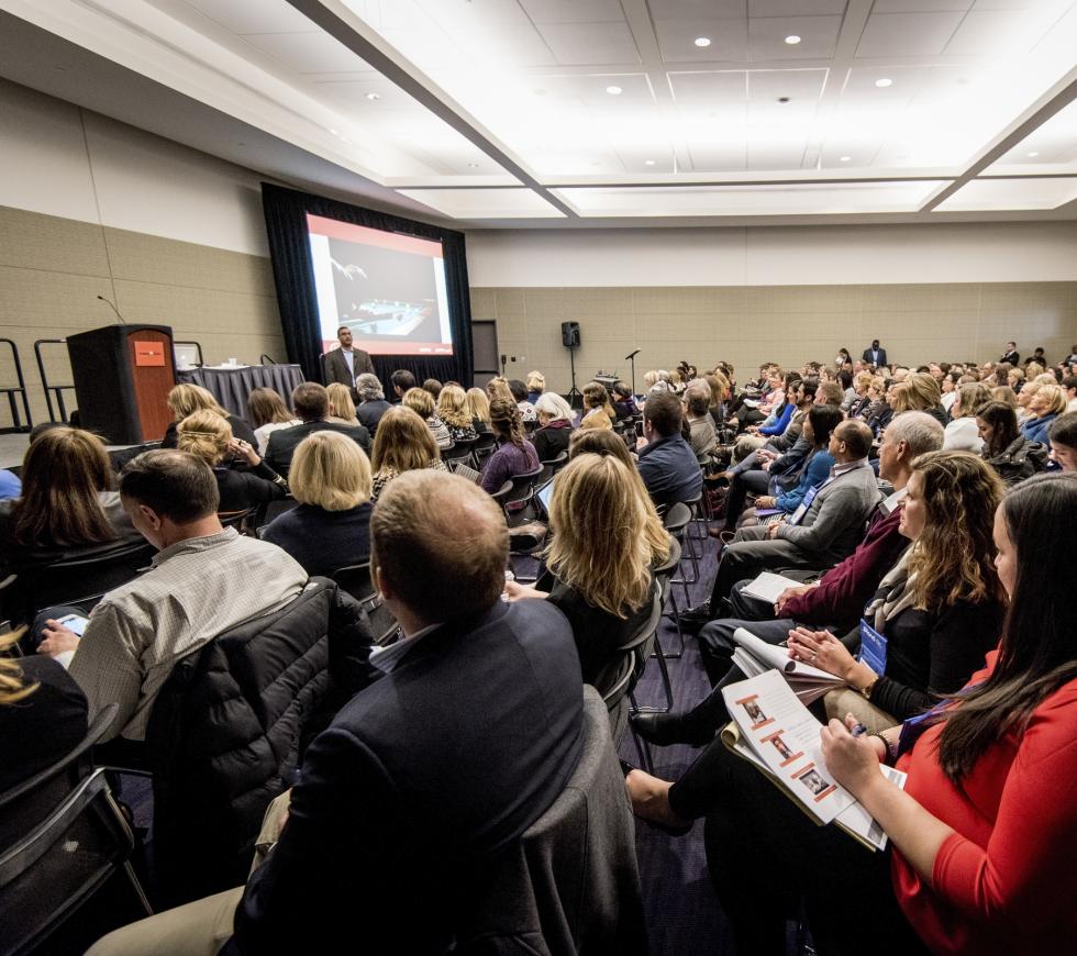 A man teaches a conference session while the audience listens