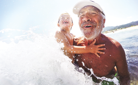 Man and child playing in the ocean