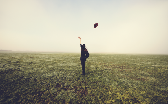 Woman throwing her hat into the air