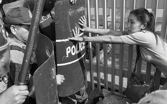 Police and a protestor clash