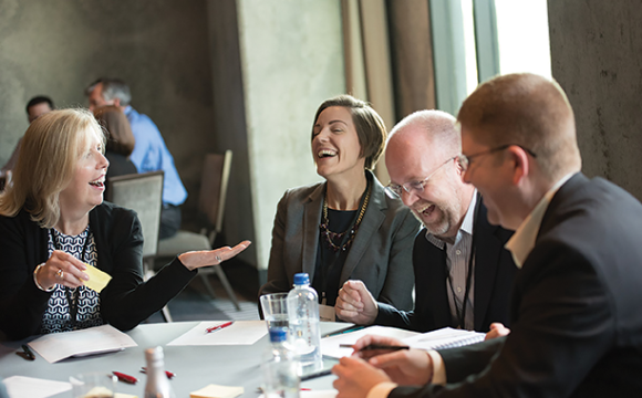 people at a table laughing and talking during a meeting