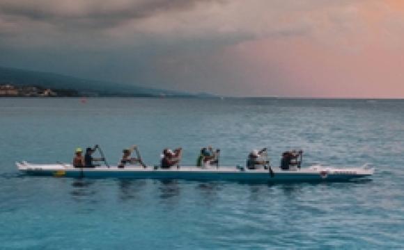 A team rowing a long canoe