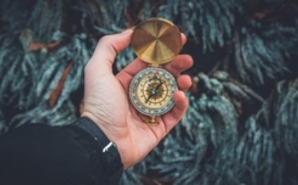 male hand holding compass