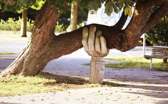 a large carved hand holding up a tree