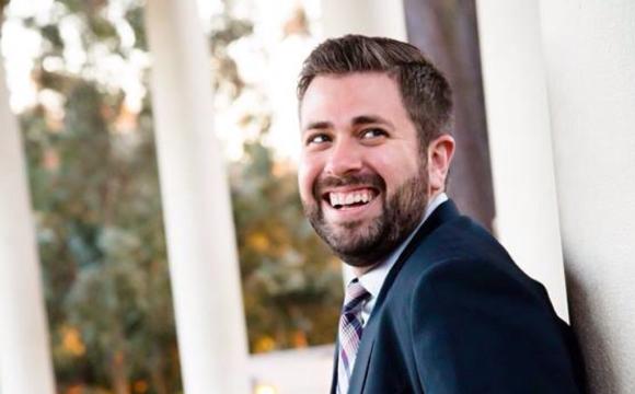 Bearded man wearing a suit smiling at the camera