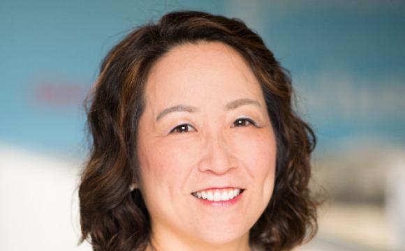 woman wearing a white sweater smiling at the camera