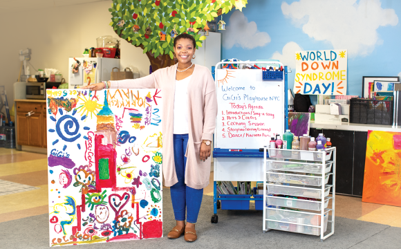 woman standing with a painting in a classroom