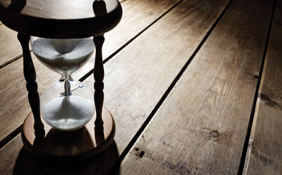 hourglass sitting on a wood floor