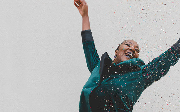 happy woman throwing confetti in the air