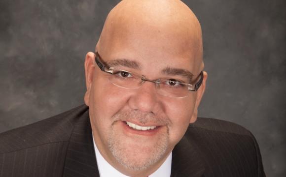 man with glasses wearing a suit jacket, white shirt and red tie