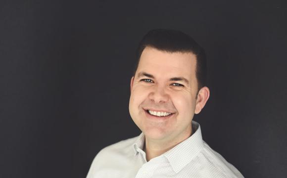 man in a white shirt smiling at the camera