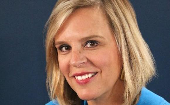 woman in a blue top smiling at the camera