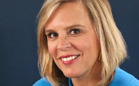 woman in a blue top smiling at the camera