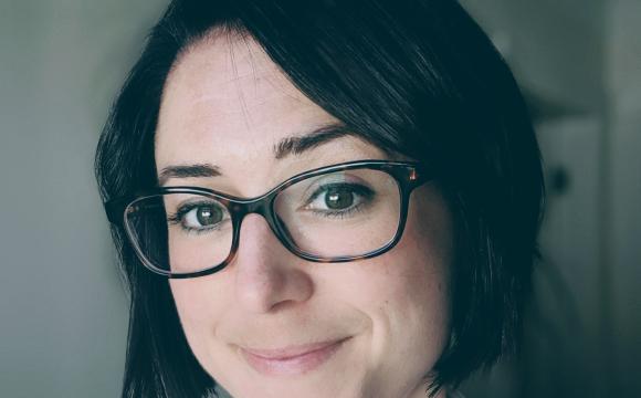 woman wearing glasses and smiling at the camera