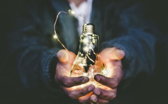 someone holding  a lightbulb in their hands