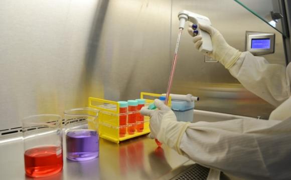 lab technician with beakers with different colored liquids