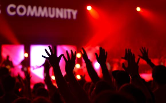 hands reaching towards sign that says community