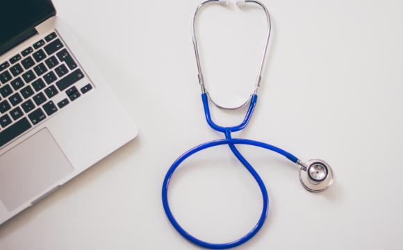 a blue stethoscope next to a laptop