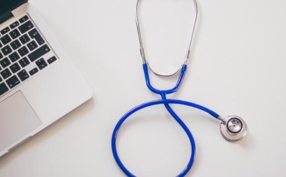 blue stethoscope next to laptop 