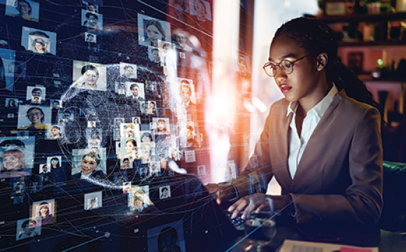 black woman working on a laptop with a digital world