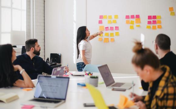 people in a board room wtih sticky notes on the wall