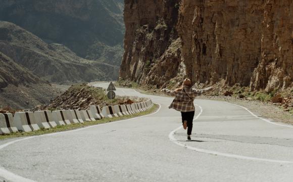 Running on road with arms open