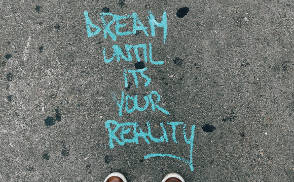 dream until its your reality written in chalk on a sidewalk