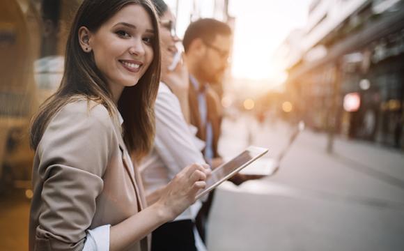 woman standing on a street with an ipad in her hand