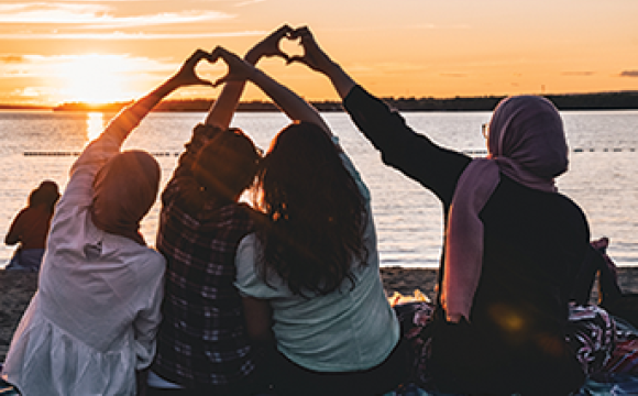 people on a beach making heart symbols