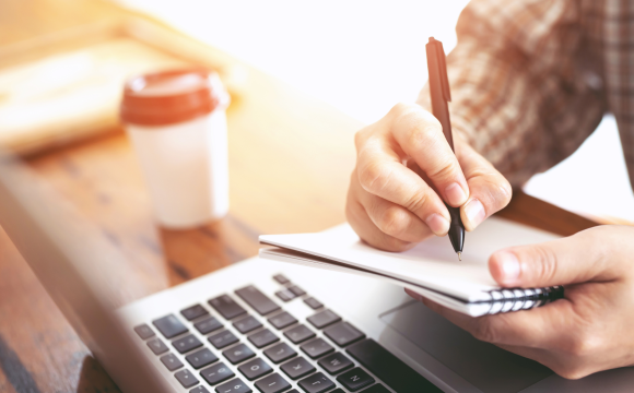 Person taking notes at a laptop