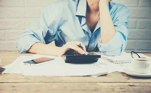 woman at a desk wtih a calculator