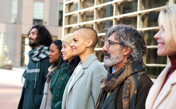 diverse group of people standing and smiling