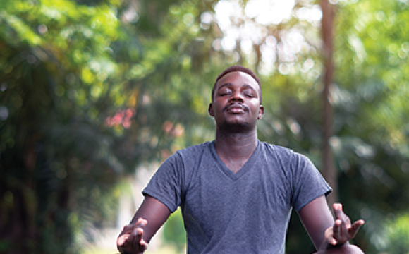 black man doing yoga in a forest