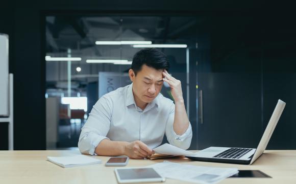 man sitting at a desk looking at papers