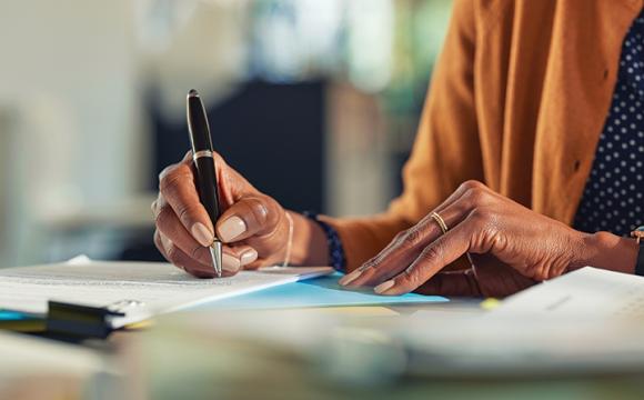 women's hand writing with a pen on paper