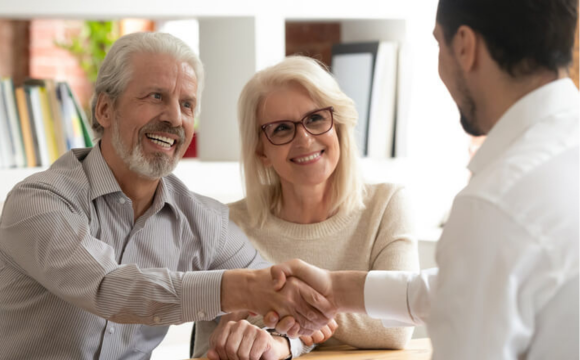 Older couple shaking hands with a man